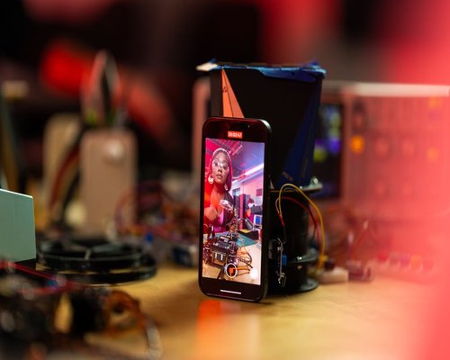Central smartphone showing the fictional Crown Spark Lab creative arcade game
